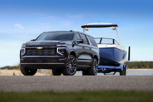Front 3/4 shot of the 2025 Suburban High Country towing a boat